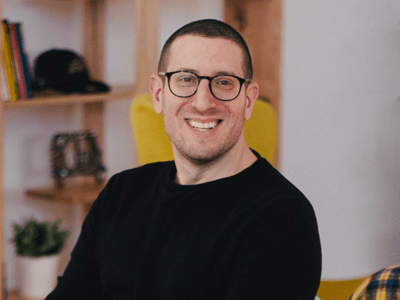 Smiling man wearing glasses, working remotely in his home office